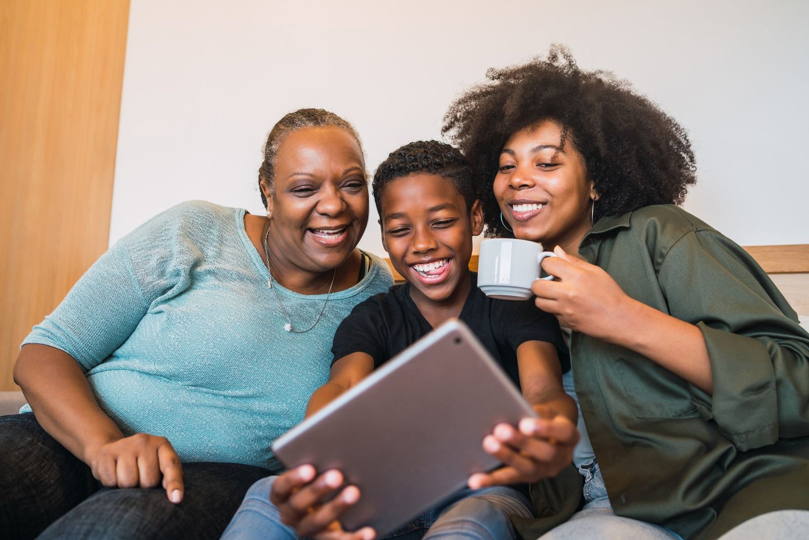 Portrait of african american grandmother, mother and son taking a selfie with digital