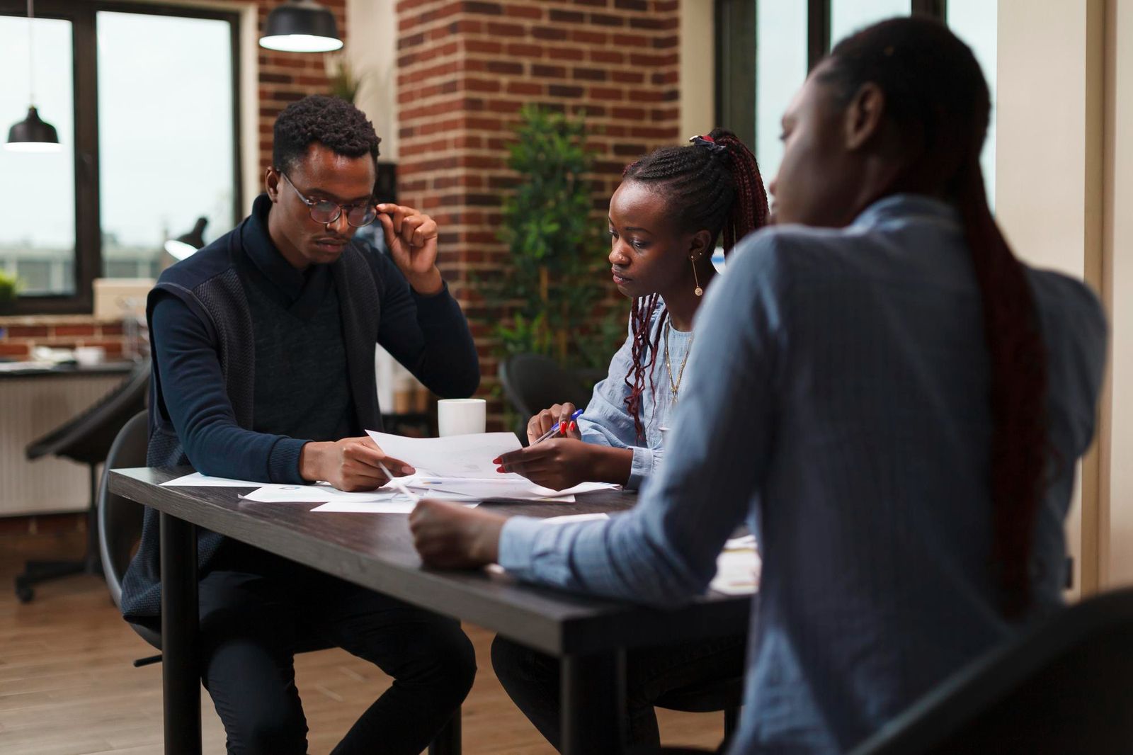 African american research agency coworkers in meeting about startup project financial status. Business people at desk in